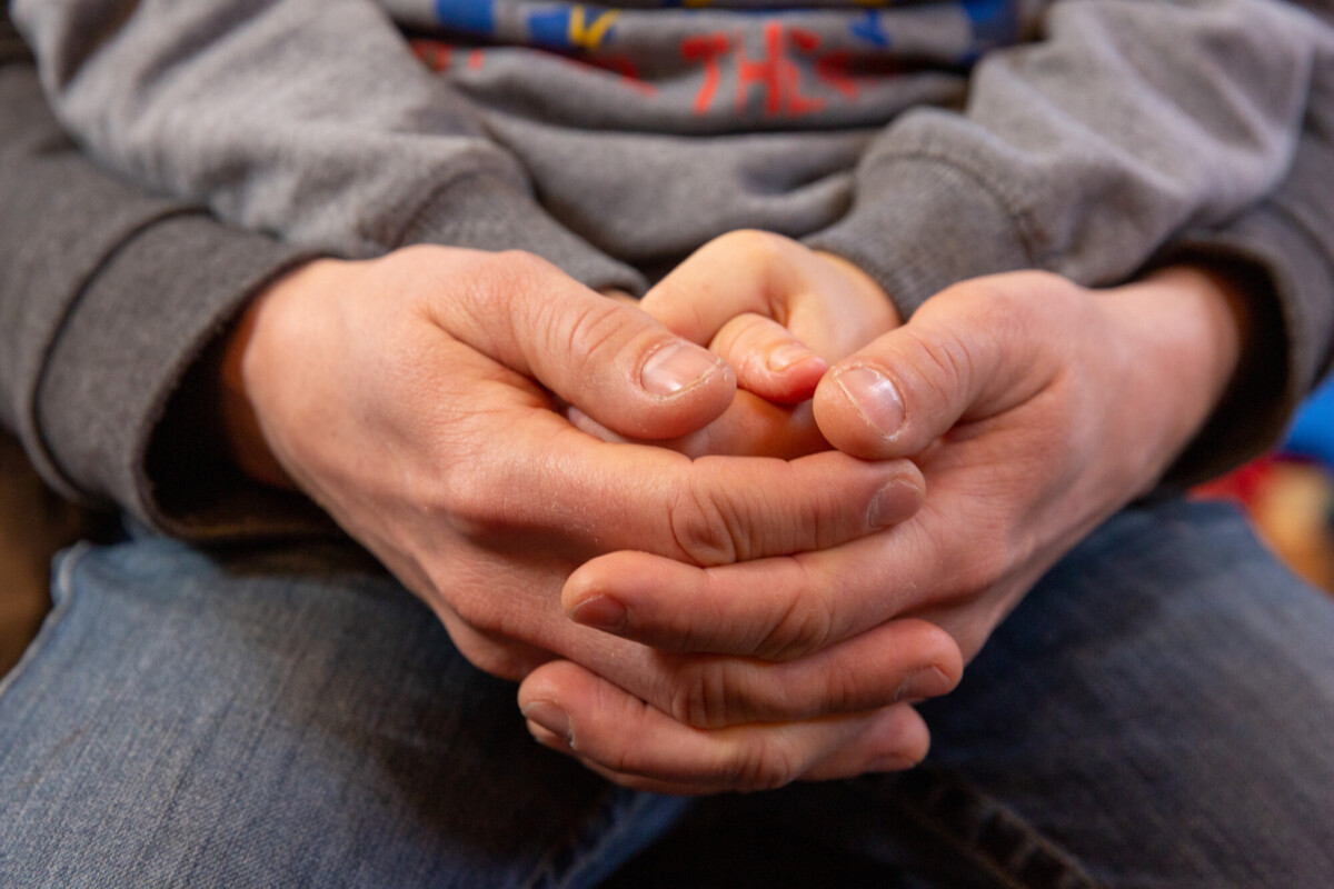 Kinderhände liegen in Erwachsenen Händen zum Gebet